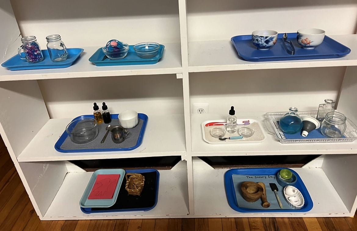 a white shelf with Montessori practical life materials